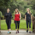 Group women in their 30s walking together in the outdoors.