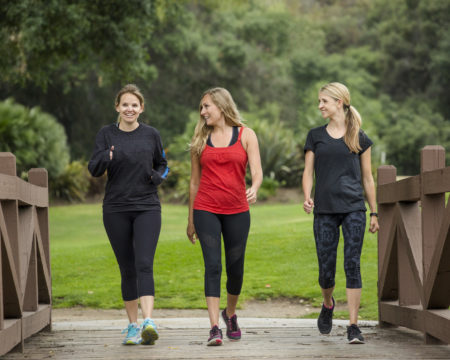 Group women in their 30s walking together in the outdoors.