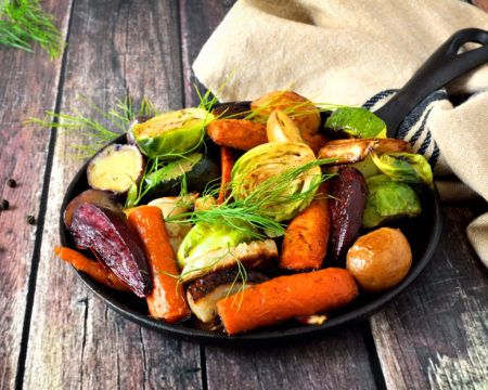 Skillet of roasted vegetables against rustic wood