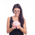 Young woman with glasses happy with piggy bank