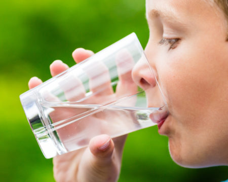 Child drinking glass of fresh water
