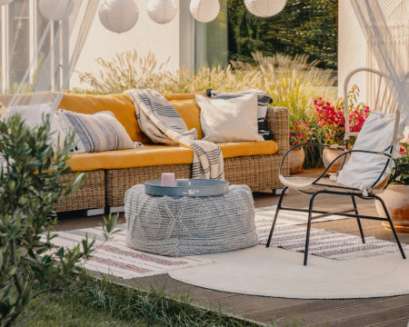 Real photo of an armchair, pouf as a table and wicker couch on a terrace