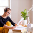 A young female student sitting at the table, using tablet when studying.