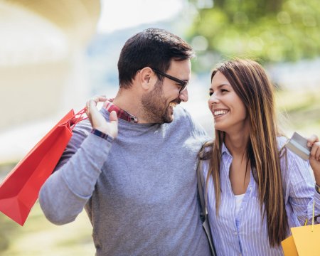 Young couple with shopping bags and credit card in the city