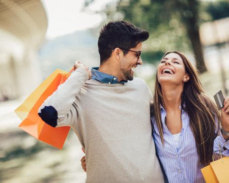 Young couple with shopping bags and credit card in the city