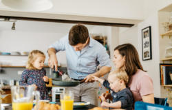 Father serving breakfast to family