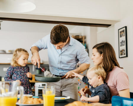 Father serving breakfast to family