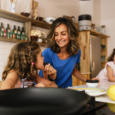 Little sisters cooking with her mother in the kitchen.