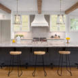 beautiful kitchen in new luxury home with island, pendant lights, and glass fronted cabinets