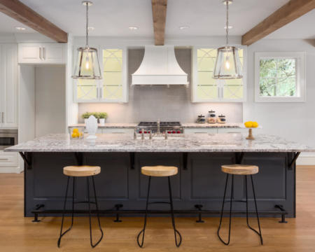 beautiful kitchen in new luxury home with island, pendant lights, and glass fronted cabinets