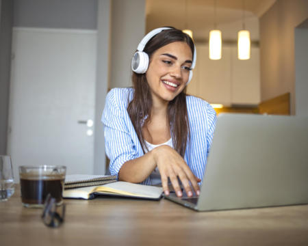 Smiling girl student wear wireless headphone study online with skype teacher