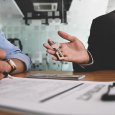 Cropped image of Real estate agent offer house insurance or house ownership to smart man in blue shirt