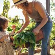 Mother and daughter with fresh vegetable in farm